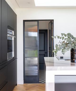 black framed glass doors between kitchen and utility