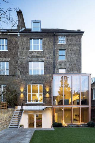 Double-height glass box extension with timber fins