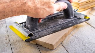 Close up of hand on manual hand sander