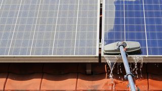 clay roof tile with solar panels on top being cleaned