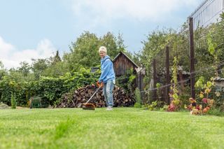 woman using lawn strimmer