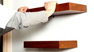 Two wooden shelves on plasterboard wall