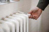 Man turning white radiator down