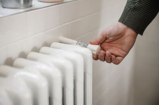 Man turning white radiator down